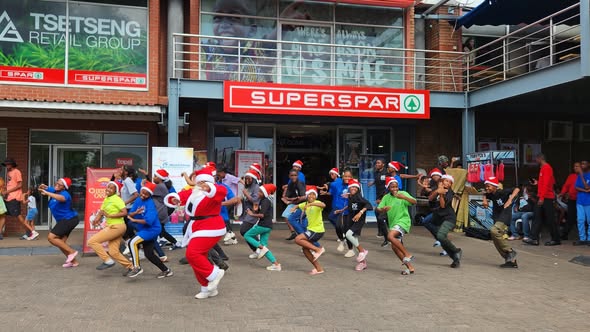 IYF dancers in Santa hats performing in front of a Spar supermarket.