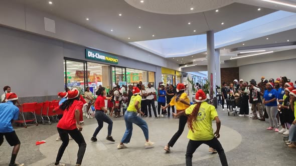 Dancers performing in a mall atrium with shoppers watching.